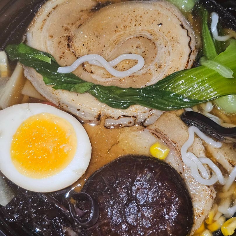 Close-up of Ramen Mama's ramen with pork, bok choy, egg, mushrooms, and corn.
