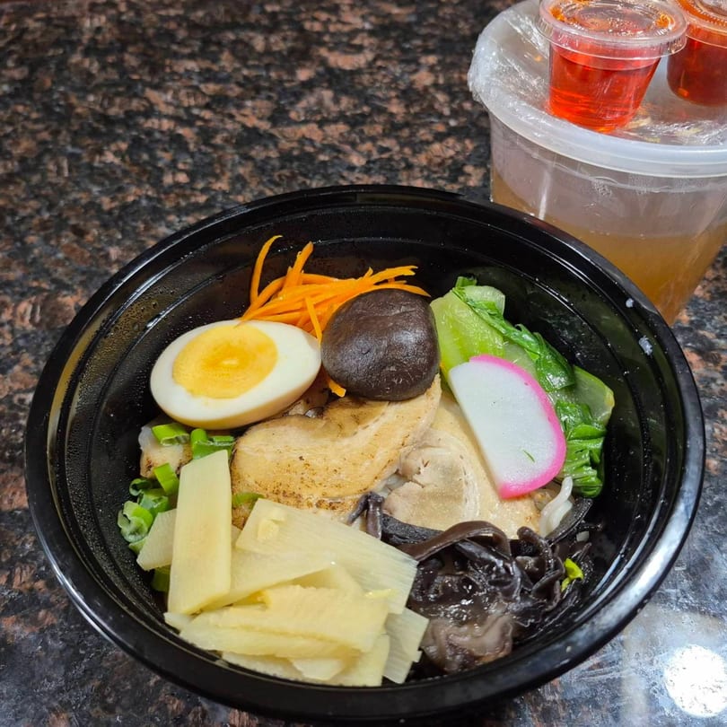 Ramen Mama's ramen bowl with egg, pork, vegetables, and broth in a separate container.